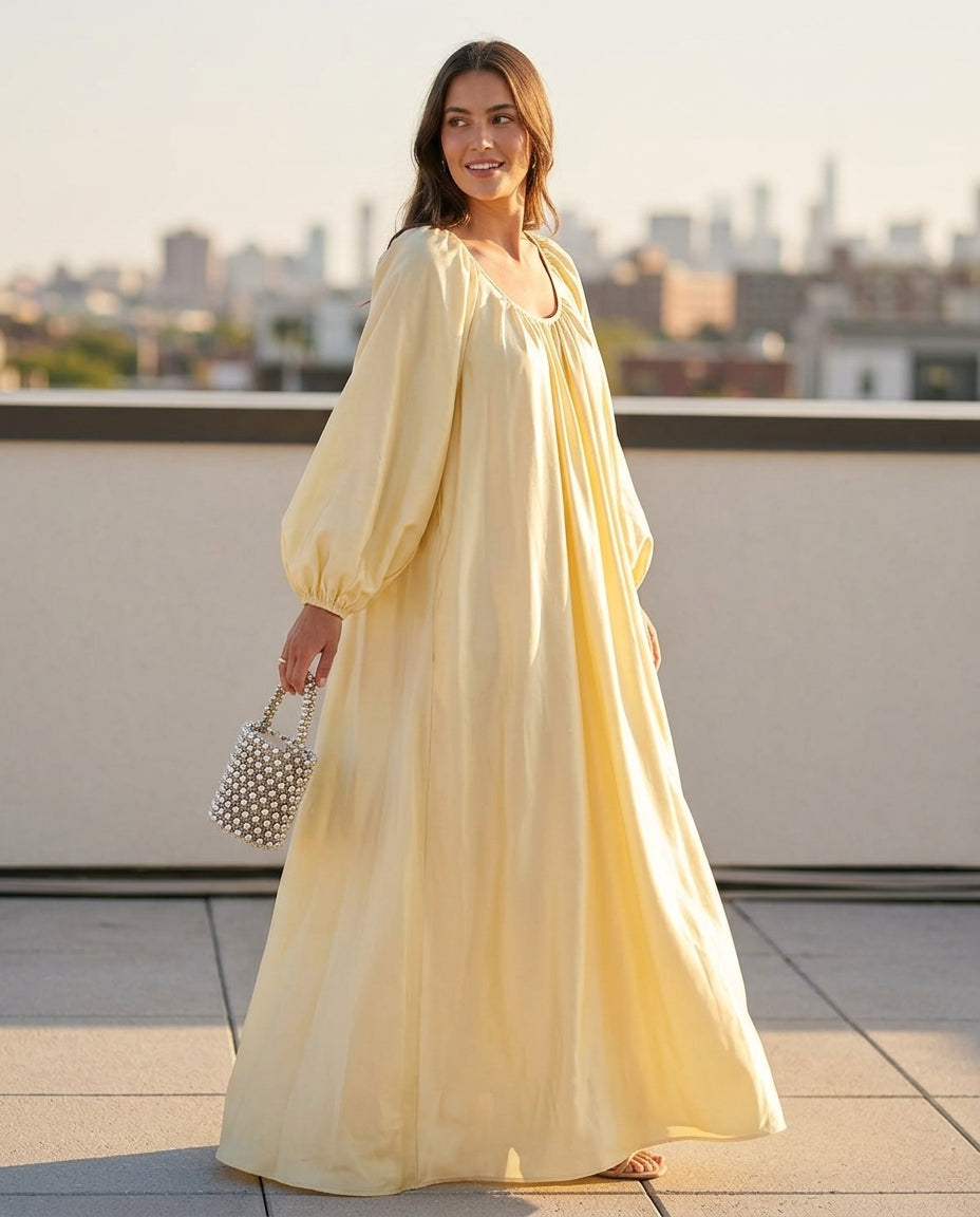 Pale Yellow Glow Resort Satin Maxi Dress Pale Yellow Maxi Dress with Relaxed Fit silhouette and Satin texture, outdoor styling image for Resort Wear, an estate dinner at golden hour, US East / Hamptons Elite by floravincie