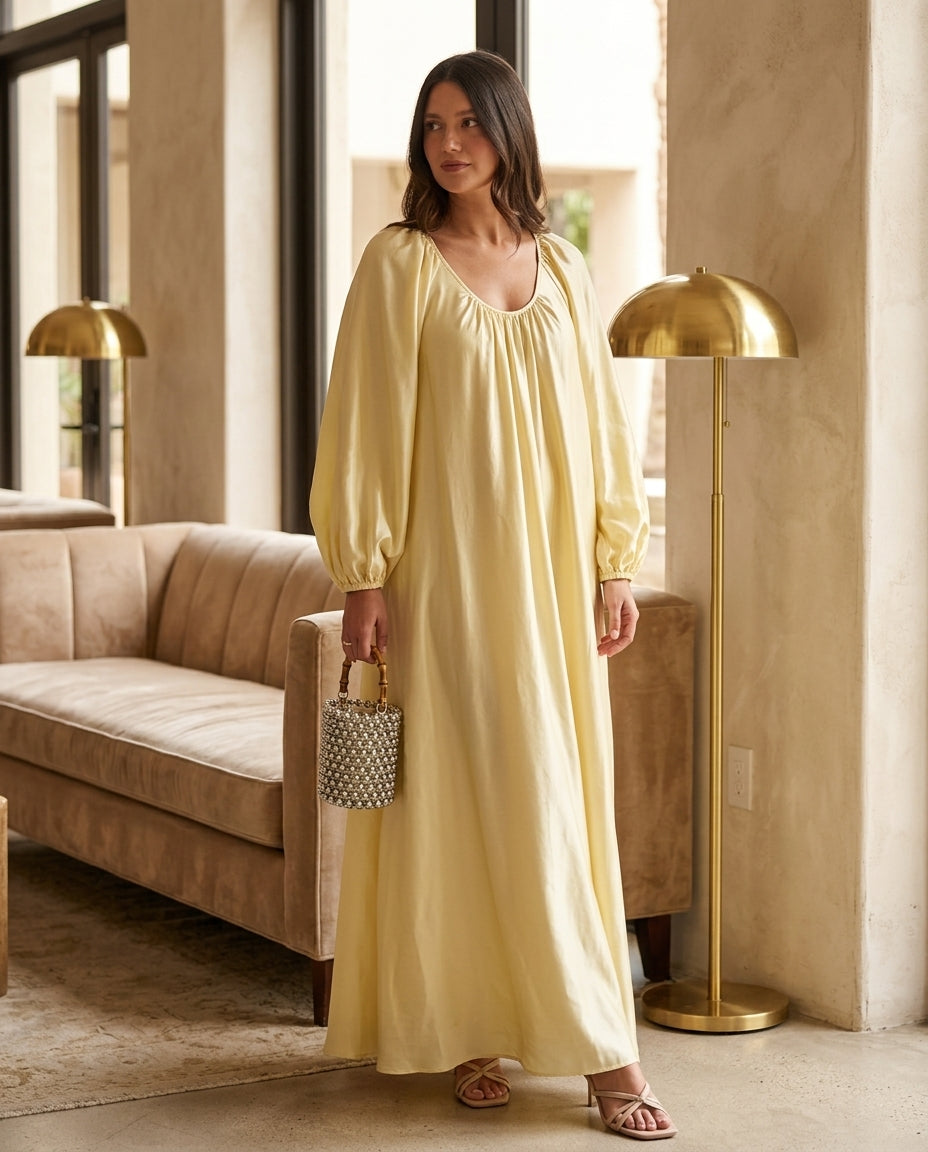 Pale Yellow Glow Resort Satin Maxi Dress Pale Yellow Maxi Dress with Relaxed Fit silhouette and Satin texture, editorial ecommerce scene for Resort Wear, an estate dinner at golden hour, US East / Hamptons Elite by floravincie